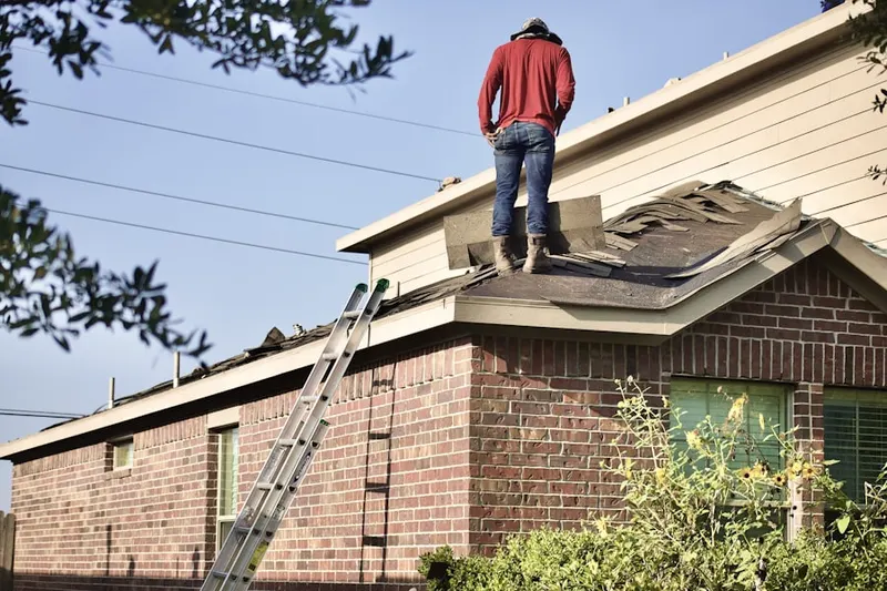 Professional roofer working on a residential roof in Scio